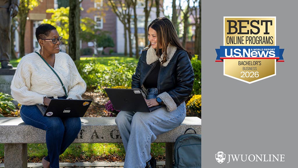 Two students sit on a bench in Gaebe Commons with their laptops; U.S. News &amp; World Report "Best Online Programs - Bachelor's Business 2026" badge