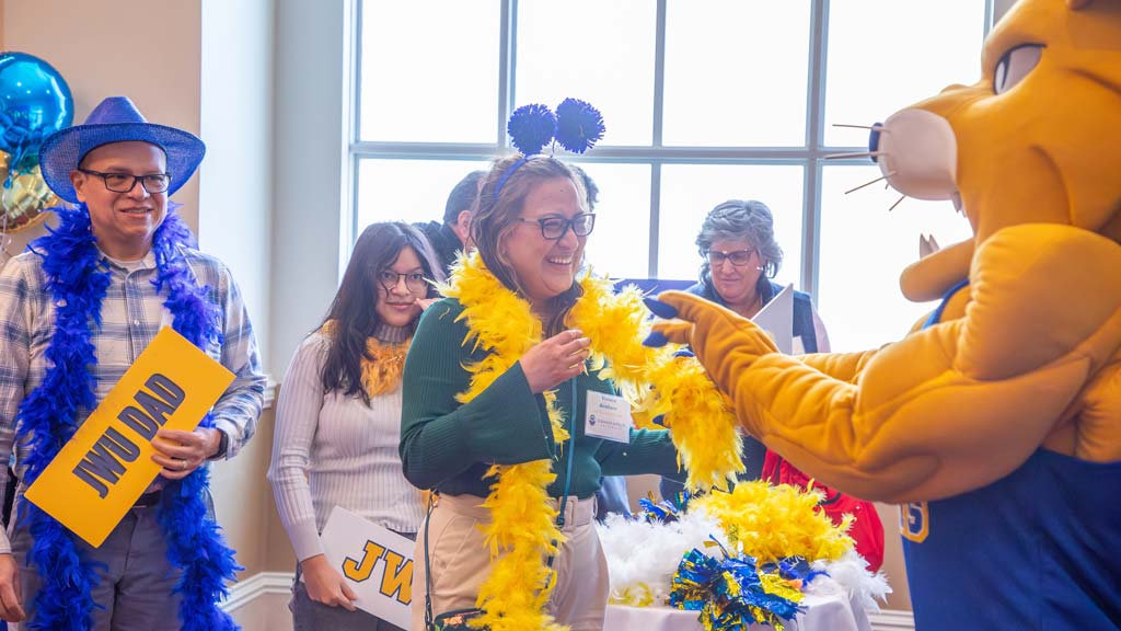 Wildcat Willie interacting with parents and students who are laughing 