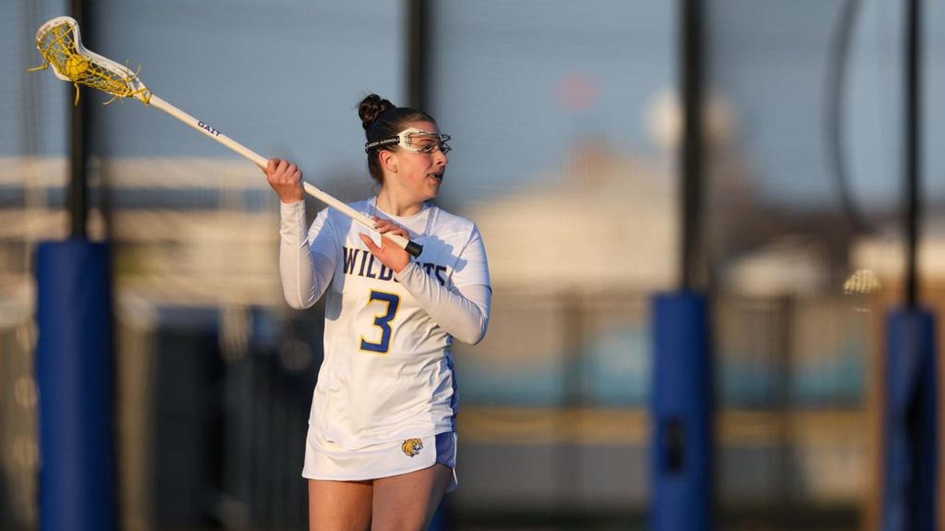 Mila holding her lacrosse stick on the field paying attention to the game