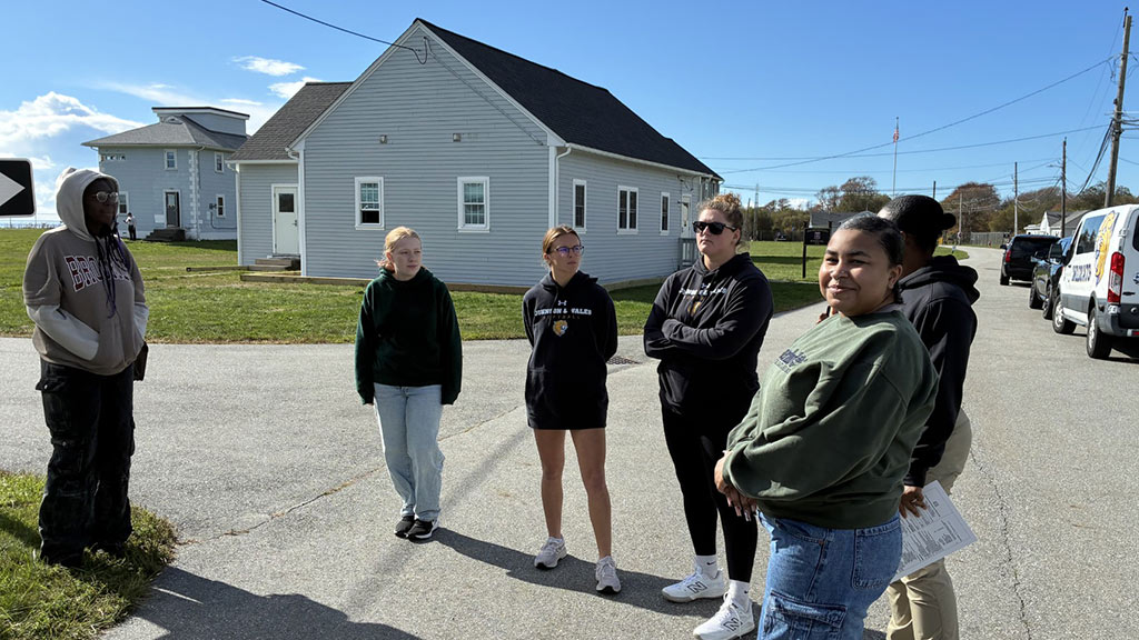 a candid shot of several JWU students on site at Camp Varnum