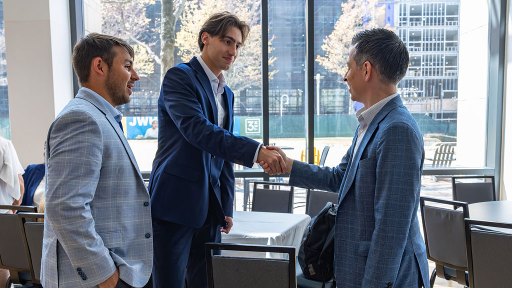 Students talking to alum Juan Garzon ’08