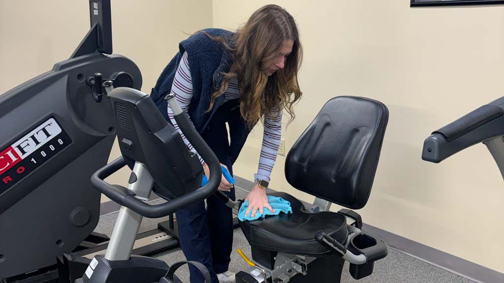 Kerra wiping down a piece of equipment at her internship