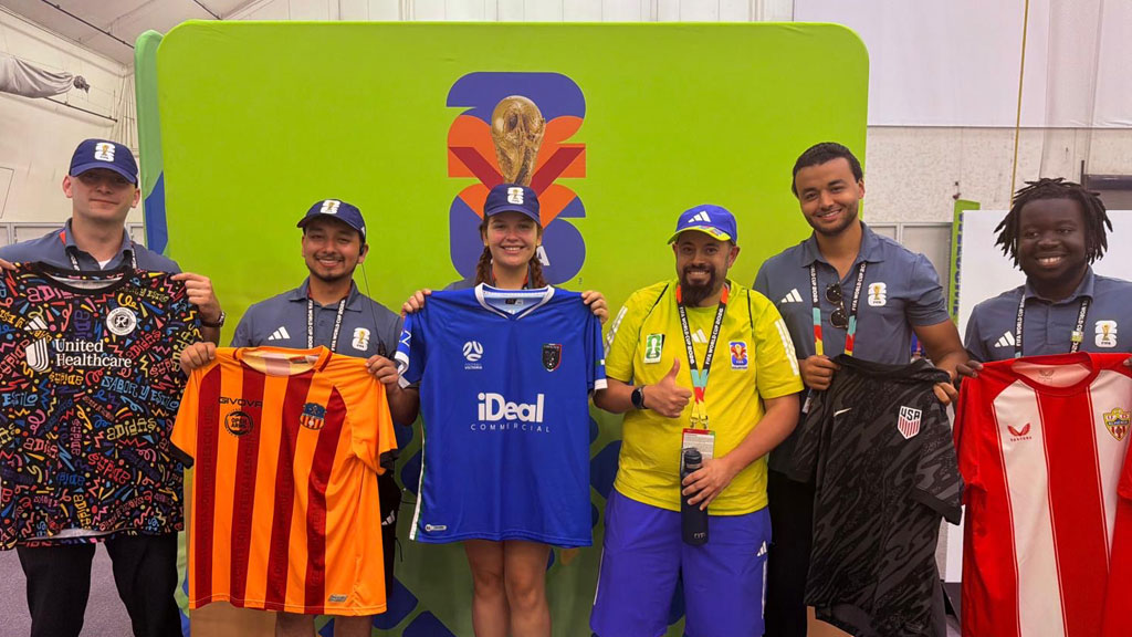 Soh Kone and Fifa colleauges hold up World Cup 2026 jerseys given to them by one of their volunteers.