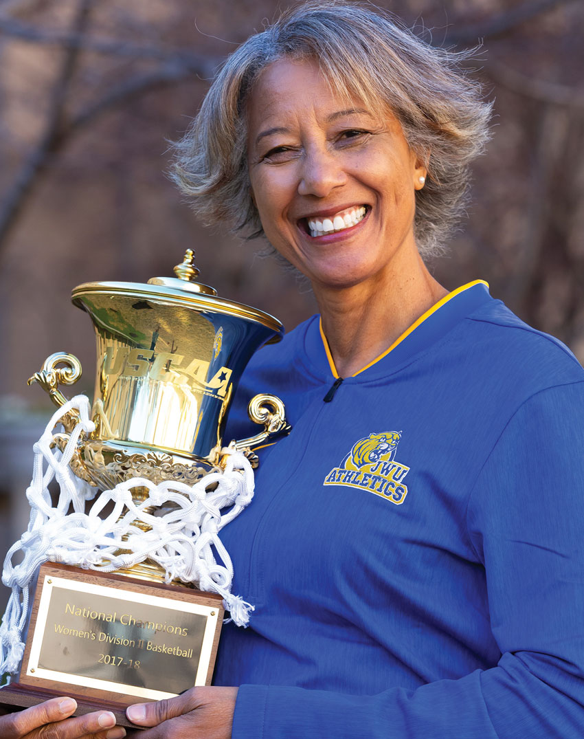 Charlotte Campus Athletics Director Trudi Lacey holding trophy