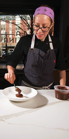 Chef Rochelle Cooper '12 crafting a pastry dish.
