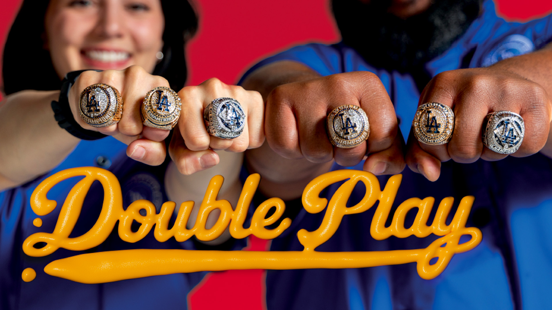 Banner showcasing the four championship rings of Tyrone Hall '05 and Kristen Loiacono '15 with "Double Play" spelled out in a yellow mustard like illustration.