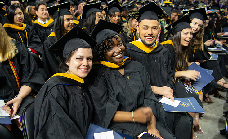 JWU students posing for a photo at graduation